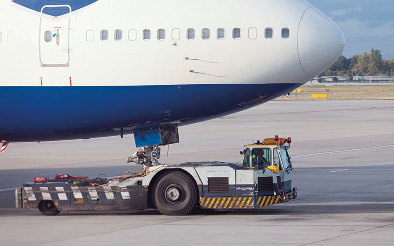 Fly transporteres med en traktor på bakken.